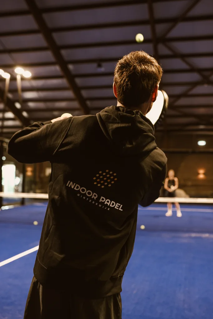 Speler met clublogo op de rug van de hoodie
